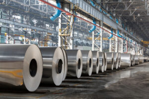 Large rolls of aluminum lined up in an El Paso warehouse.